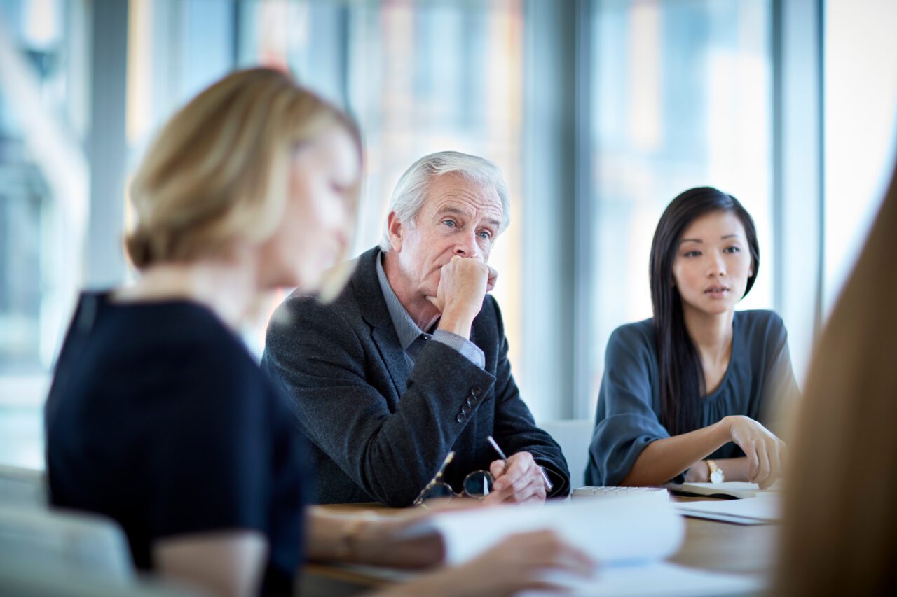 Attentive_senior_businessman listening in meeting about change of operation